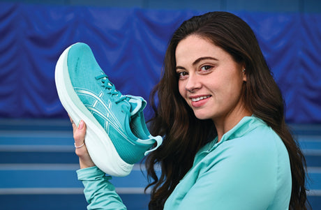Irish athlete Aoife McGrath holding a pair of blue Asics Gel-Nimbus 27 runners