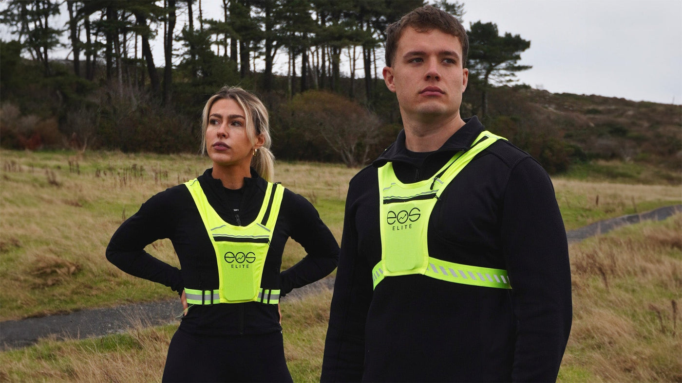 An image of man & woman wearing the EOS running vest staring into the distance in an outdoor country running setting
