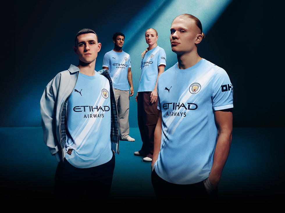 Four individuals wearing the latest Manchester City clothing range