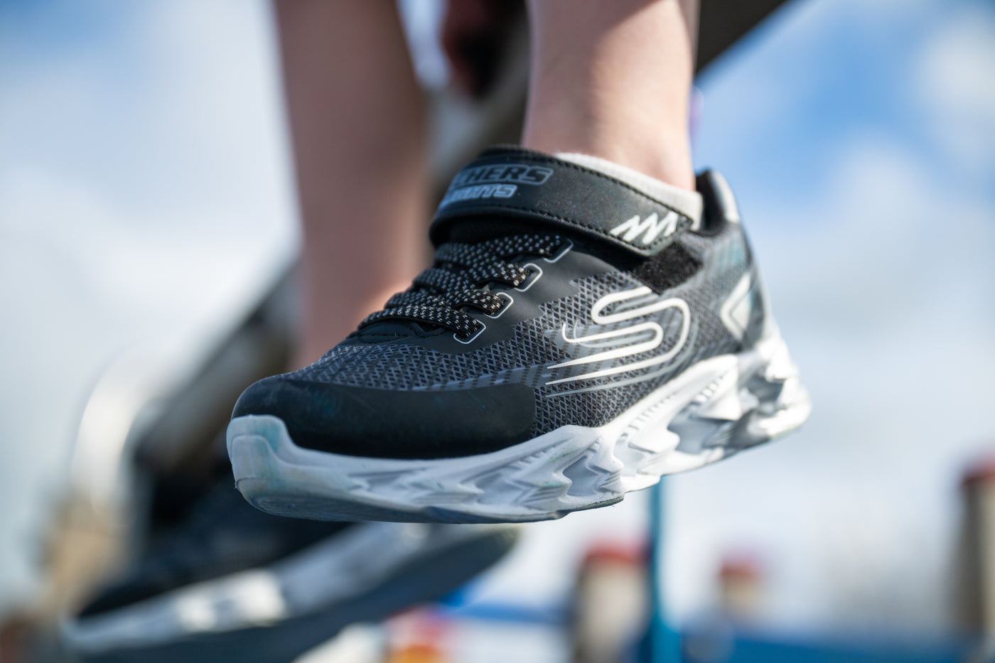 A kid wearing Sketchers runners