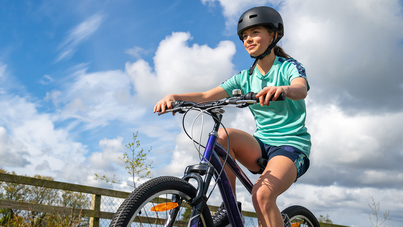A young girl cycling a bike in the sunshine