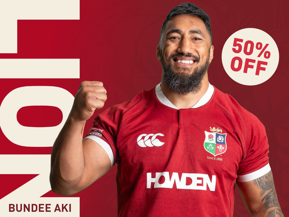 An image of Bundee Aki holding his arm in the air whilst wearing the 2025 British Irish Lions Jersey, also there is a 50% sticker on the top right