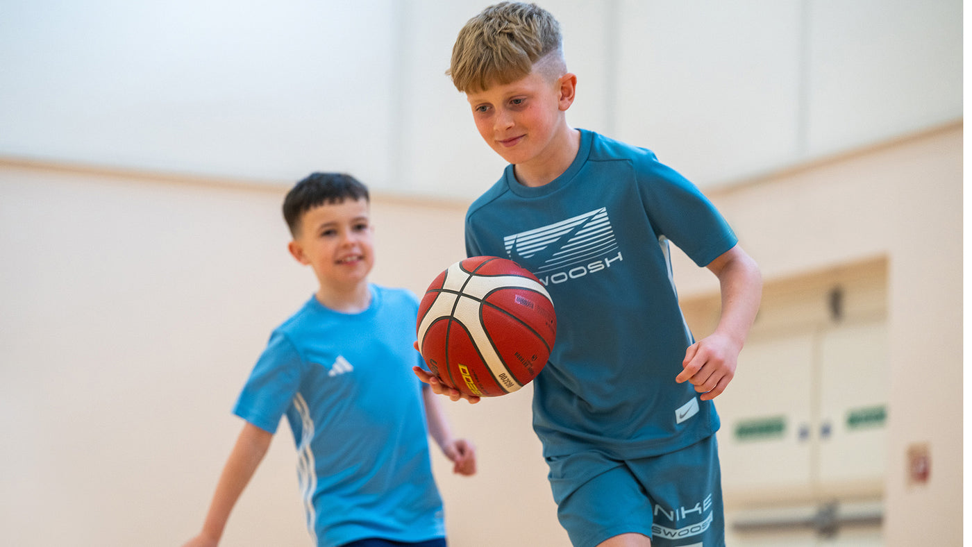 Two kids playing basketball